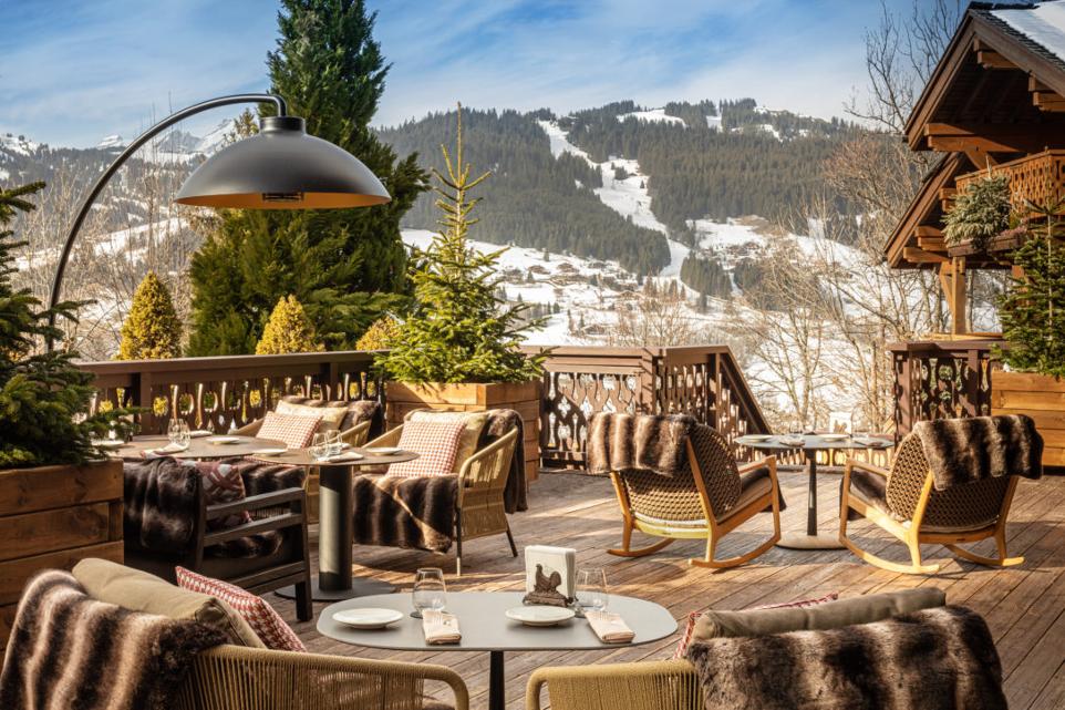 Heatsail DOME terrasheater op een ingericht winterterras met uitzicht op besneeuwde bergen