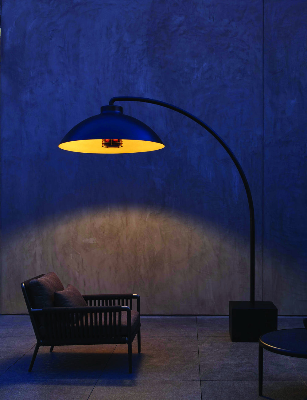 Heatsail DOME met warm licht bij een loungestoel op een beschut terras
